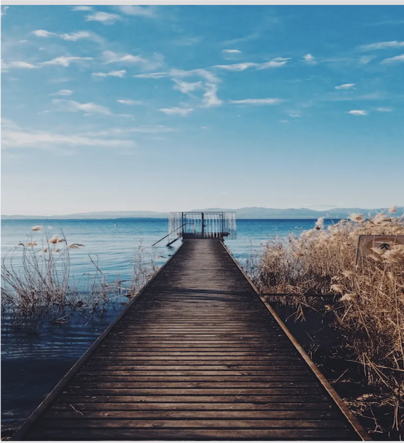 A wooden pier stretching out over calm blue water